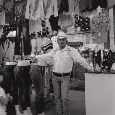 Vendor for western wear at indoor flea market.