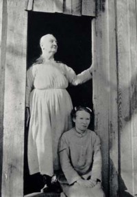 Emma Dusenbury and her daughter in the doorway of their home, as featured in the poster for the folk music exhibit from Special Collections.