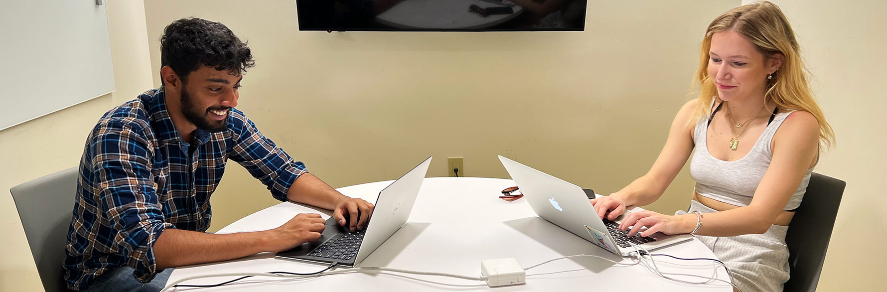 two students working together on laptops